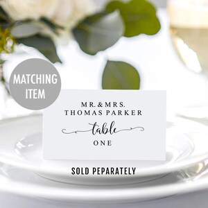 Puede incluir: Tarjeta de n&uacute;mero de mesa blanca con texto negro que dice "Mr. & Mrs. Thomas Parker mesa uno".
