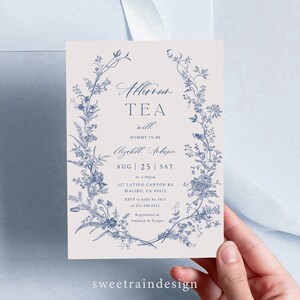 Pu&ograve; includere: Un invito a un baby shower con un designo floreale blu e bianco con il testo "Afternoon Tea" e "Mommy to be Elizabeth Arbezen" con la data "Aug | 25 | Sat" alle 13:00. L'invito include l'indirizzo "327 Latigo Canyon Rd Malibu, CA 90412" e le informazioni RSVP.