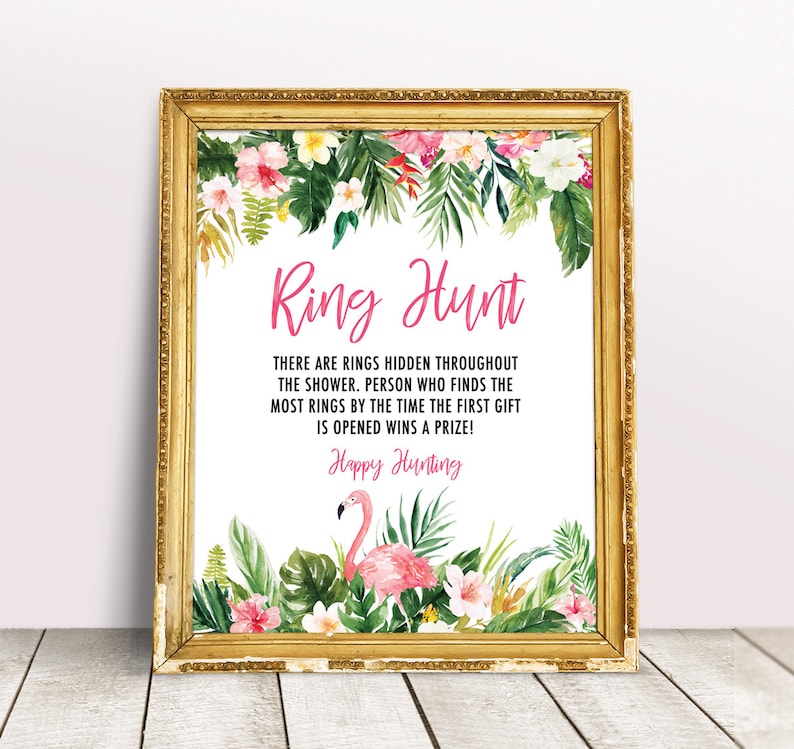 May include: A printable sign with a tropical theme for a ring hunt game. The sign has a pink flamingo, green leaves, and pink flowers. The text on the sign reads "Ring Hunt" and "There are rings hidden throughout the shower. Person who finds the most rings by the time the first gift is opened wins a prize! Happy Hunting!"