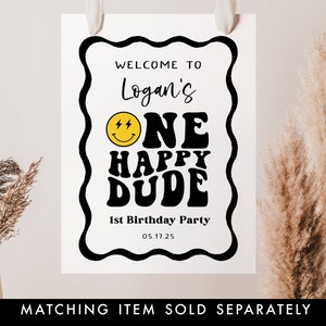 May include: A black and white welcome sign with a yellow smiley face and the text "Welcome to Logan's One Happy Dude 1st Birthday Party 05.17.25".