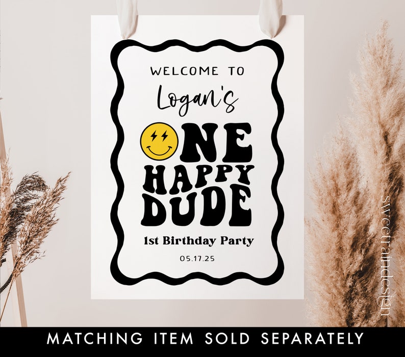 May include: A black and white welcome sign with a yellow smiley face and the text "Welcome to Logan's One Happy Dude 1st Birthday Party 05.17.25".