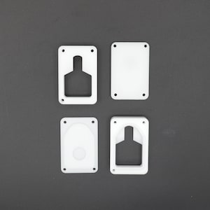 Puede incluir: Cuatro placas de plástico blanco con diferentes recortes. Las placas están dispuestas en una cuadrícula sobre una superficie gris.