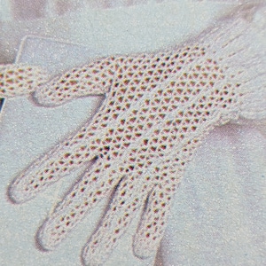 May include: A white crocheted glove with a delicate pattern. The glove is made with a fine yarn and has a delicate, feminine look.