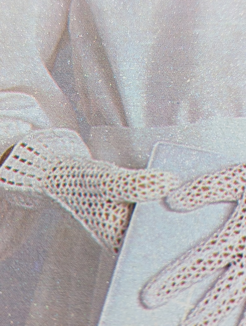 May include: A pair of white crocheted gloves with a delicate pattern. The gloves are made of a fine, lightweight material and have a soft, comfortable feel.