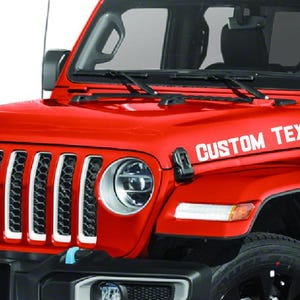 May include: Red Jeep Wrangler with a white custom text decal on the hood that says "CUSTOM TEXT".