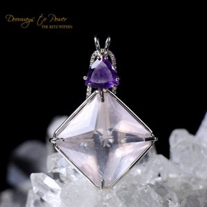 Puede incluir: Un colgante plateado con un cristal grande, rosa claro, tallado en forma cuadrada y un cristal triangular, morado, m&aacute;s peque&ntilde;o encima. El colgante est&aacute; sobre un fondo negro y descansa sobre cristales transparentes. Texto: "Doorways to Power THE KEYS WITHIN."