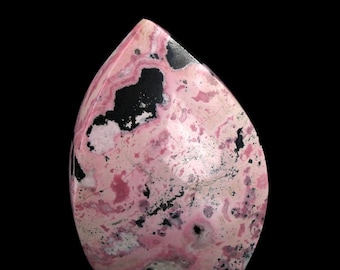 Può includere: Una pietra preziosa rosa e nera lucidata con una forma unica a forma di lacrima. La pietra presenta un motivo a spirale di rosa, bianco e nero.