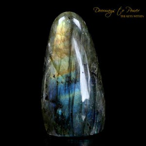 May include: A smooth, polished, teardrop-shaped labradorite crystal with iridescent blue, green, and gold colors. The crystal is a natural stone and has a unique, organic shape.