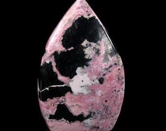 Può includere: Una punta di cristallo di Rodonite lucidata, con un motivo a spirale unico in rosa e nero. Il cristallo ha la forma di una lacrima e una superficie liscia e lucidata.