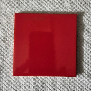 May include: A solid red square tile with a glossy finish.