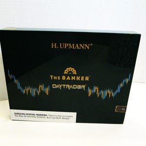 May include: A black box featuring gold text reading "H. Upmann", "The Banker", and "Daytrader". The box displays a stock market chart graphic and a Surgeon General's warning.