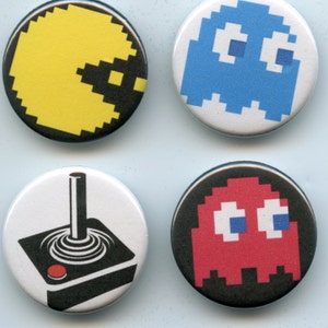 May include: Four round pinback buttons featuring retro video game designs. Includes a yellow Pac-Man, a blue ghost, a black and white joystick, and a red ghost. These buttons are perfect for gamers and fans of classic arcade games.