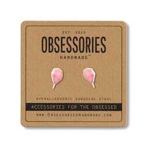 May include: A pair of pink petal-shaped earrings on a brown card. The card reads "OBSESSORIES HANDMADE" and "ACCESSORIES FOR THE OBSESSED". The earrings are made of hypoallergenic surgical steel.