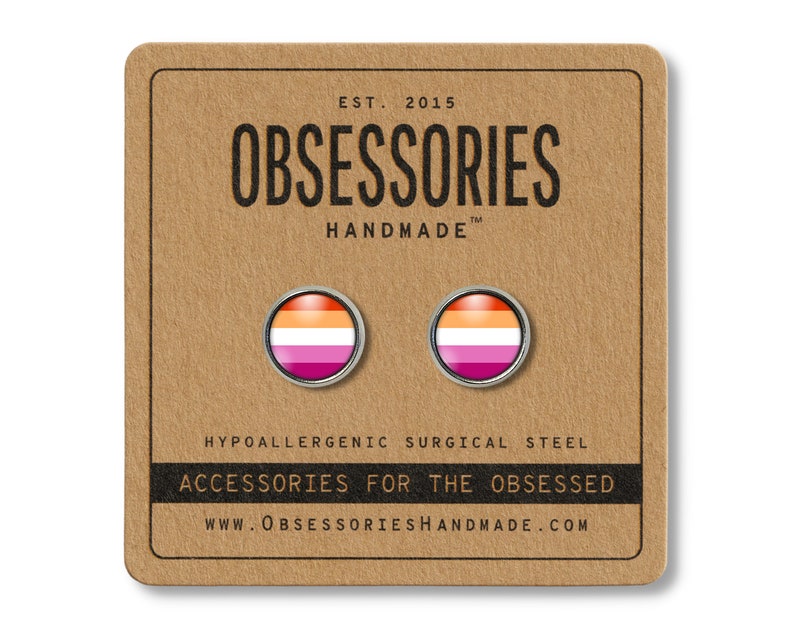 May include: A pair of round stud earrings featuring the lesbian pride flag design, set against a silver metal frame. The earrings are displayed on a brown card with the text "OBSESSORIES HANDMADE" and "ACCESSORIES FOR THE OBSESSED".