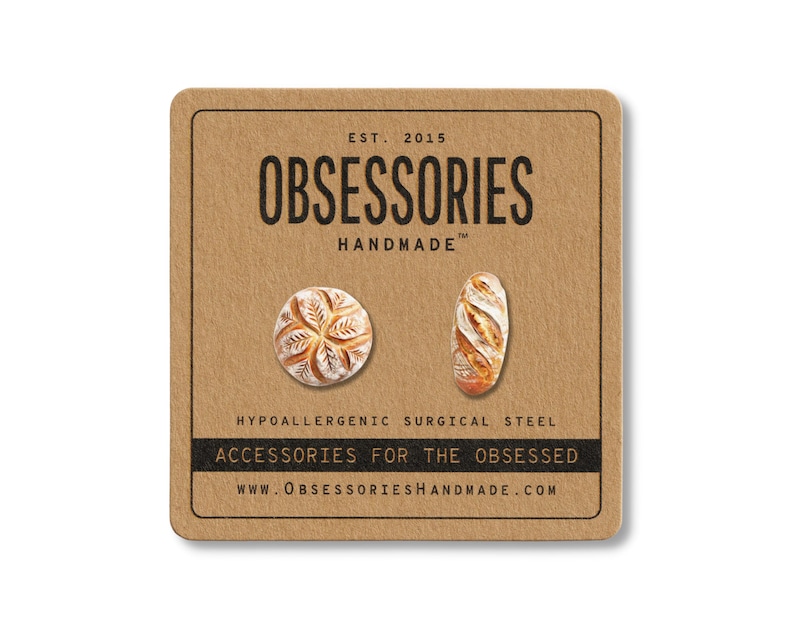 Może przedstawiać: Brązowa karta z napisem "OBSESSORIES HANDMADE" i dwiema kolczykami w kształcie chleba. Jeden kolczyk jest okrągły, drugi owalny. Karta zawiera r&oacute;wnież tekst "ACCESSORIES FOR THE OBSESSED" i "WWW.OBSESSORIESHANDMADE.COM".