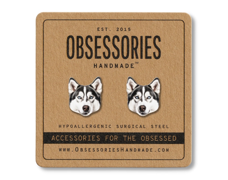 May include: A pair of hypoallergenic surgical steel stud earrings featuring a detailed illustration of a husky dog's face. The earrings are displayed on a brown card with the text "OBSESSORIES HANDMADE" and "ACCESSORIES FOR THE OBSESSED".
