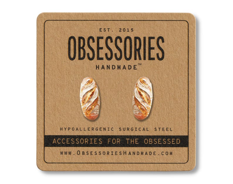 Może przedstawiać: Kolczyki sztyfty w kształcie miniaturowych bagietek, prezentowane na brązowej karcie. Karta zawiera tekst "OBSESSORIES HANDMADE" i "ACCESSORIES FOR THE OBSESSED". Kolczyki wykonane są z hipoalergicznej stali chirurgicznej.