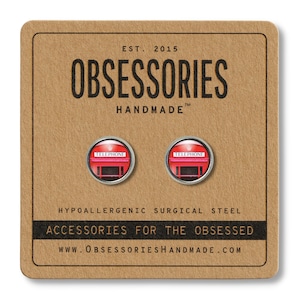 Puede incluir: Un par de pendientes de cabina telef&oacute;nica roja con detalles plateados. Los pendientes son hipoalerg&eacute;nicos y est&aacute;n hechos de acero quir&uacute;rgico. La tarjeta dice "OBSESSORIES HANDMADE" y "ACCESSORIES FOR THE OBSESSED".