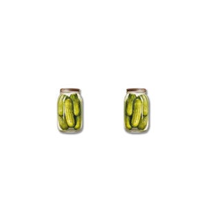 May include: Two glass jars filled with green pickles. Each jar has a metal lid and is filled with several whole pickles. The jars are set against a white background.