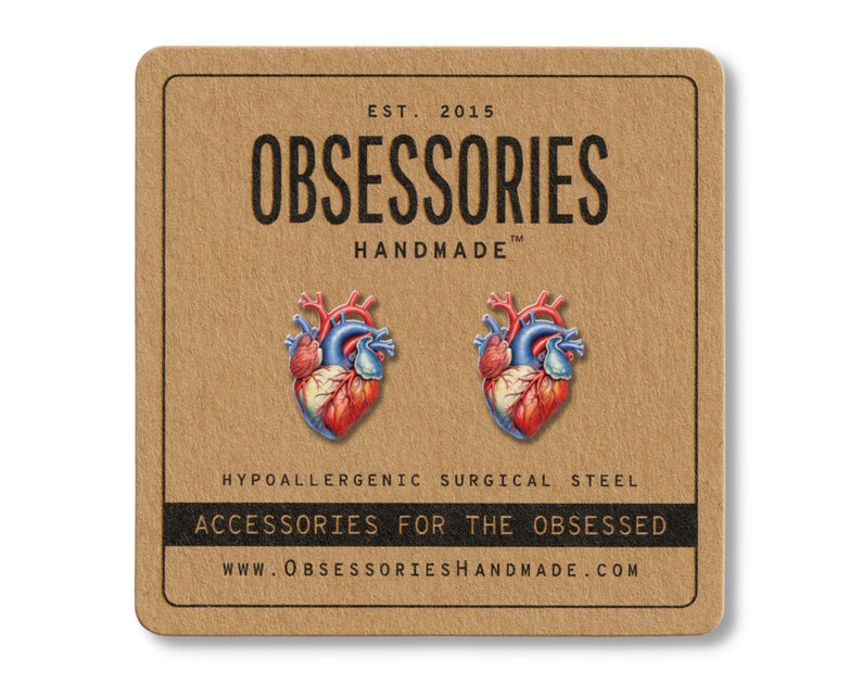 May include: A pair of anatomical heart-shaped earrings. The earrings are red, blue, and white, and are displayed on a brown card with the text "OBSESSORIES HANDMADE" and "ACCESSORIES FOR THE OBSESSED".