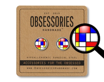 Könnte beinhalten: Ein Paar kleine, runde Ohrringe mit einem geometrischen Design in Rot, Gelb, Blau und Weiß. Die Ohrringe sind aus hypoallergenem Chirurgenstahl gefertigt und mit "OBSESSORIES HANDMADE" gekennzeichnet.