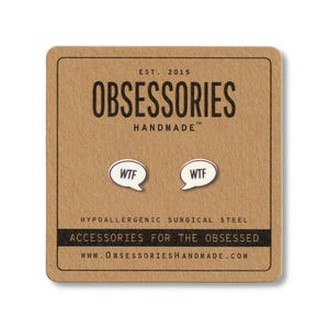 Puede incluir: Pendientes de botón plateados con forma de bocadillo "WTF" sobre una tarjeta marrón. La tarjeta tiene el texto "OBSESSORIES HANDMADE" y "ACCESSORIES FOR THE OBSESSED". Los pendientes son de acero quirúrgico hipoalergénico.