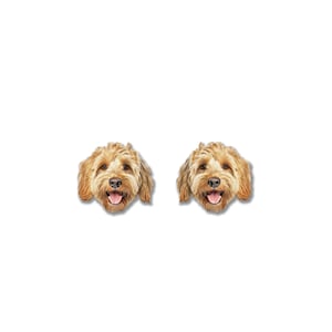 Pu&ograve; includere: Un paio di orecchini a forma di cane. Ogni orecchino presenta un volto di cane sorridente con pelo marrone chiaro e una lingua rosa. Gli orecchini sono su sfondo bianco.