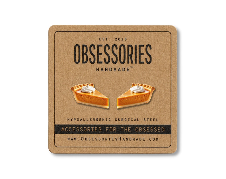 May include: A square, brown card with the text "OBSESSORIES HANDMADE" and two pumpkin pie slice earrings. The card also includes the text "ACCESSORIES FOR THE OBSESSED" and "WWW.OBSESSORIESHANDMADE.COM".