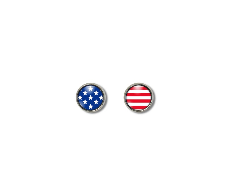 Pode incluir: Dois bot&otilde;es redondos de cor prateada com um design de bandeira americana azul e branca e um design de bandeira americana vermelha e branca listrada.