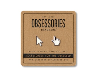 May include: A pair of silver-colored cursor and hand-shaped earrings on a brown card. The card reads "OBSESSORIES HANDMADE" and "ACCESSORIES FOR THE OBSESSED". The earrings are made of hypoallergenic surgical steel.