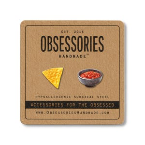 May include: A square, brown card with the text "OBSESSORIES HANDMADE" and the website address. The card features a yellow tortilla chip and a small bowl of salsa. The text "ACCESSORIES FOR THE OBSESSED" is also visible.