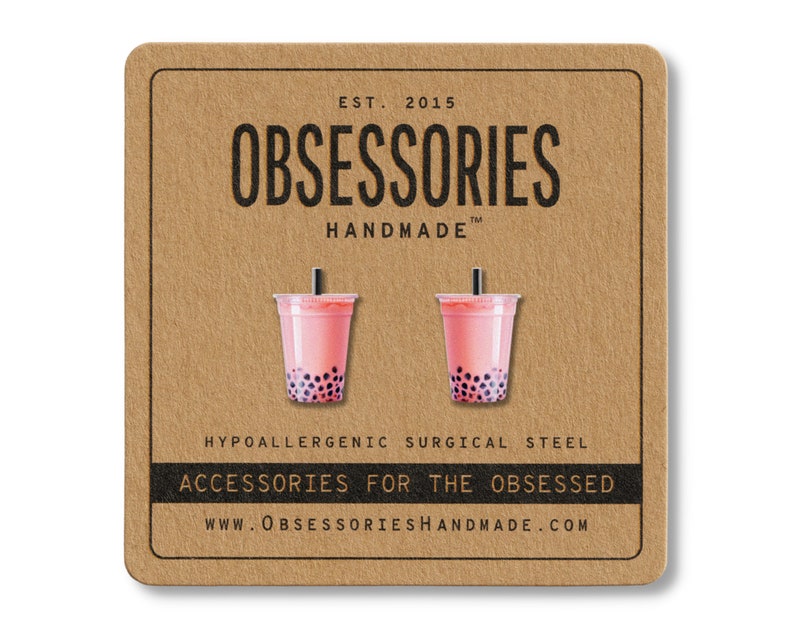 May include: A pair of pink bubble tea earrings with black boba pearls, presented on a brown card. The card features the text "OBSESSORIES HANDMADE" and "ACCESSORIES FOR THE OBSESSED". The earrings are made of hypoallergenic surgical steel.