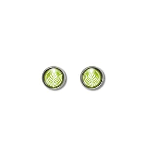 May include: A pair of silver stud earrings with a green and white latte art design.
