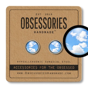 May include: A pair of hypoallergenic surgical steel earrings with a blue sky and white clouds image. The earrings are on a brown card with the text "EST. 2015 OBSESSORIES HANDMADE TM HYPOALLERGENIC SURGICAL STEEL ACCESSORIES FOR THE OBSESSED WWW.OBSESSORIESHANDMADE.COM".