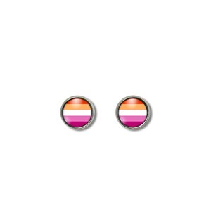 May include: Two round stud earrings with a silver-colored border. Each earring features the lesbian pride flag design, with horizontal stripes of orange, white, and pink. The earrings are set against a white background.