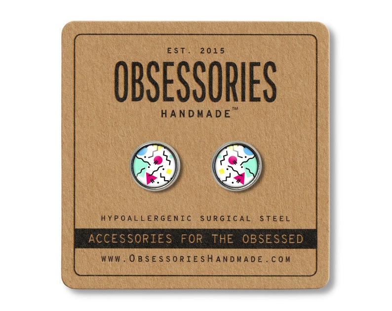 K&ouml;nnte beinhalten: Ein Paar silberne Ohrstecker mit einem geometrischen Design in Pink, Blau, Gelb und Wei&szlig; auf einer braunen Karte mit dem Text "OBSESSORIES HANDMADE" und "ACCESSORIES FOR THE OBSESSED".