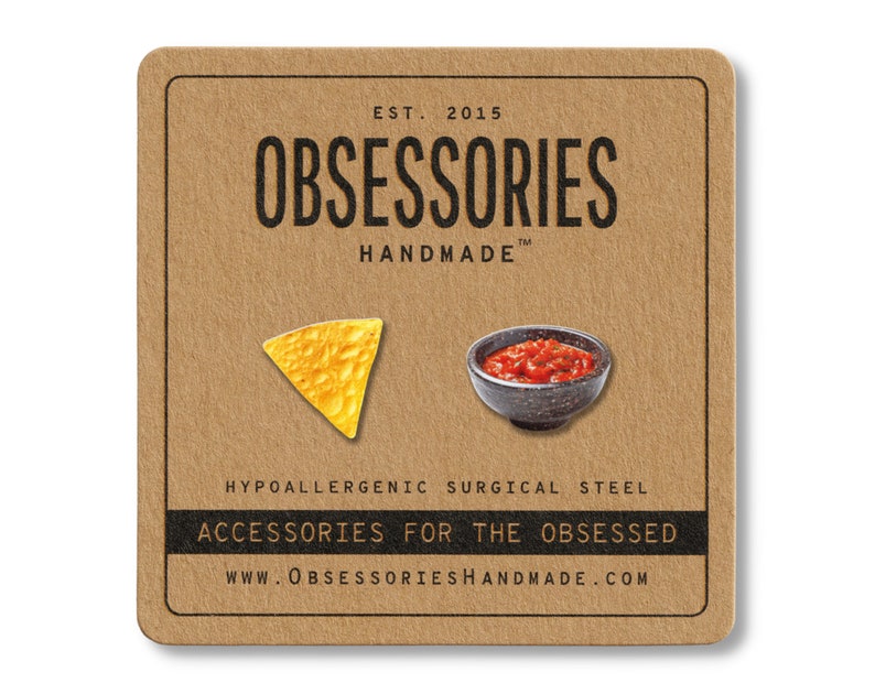 May include: A square, brown card features a yellow tortilla chip and a small bowl of salsa. The card has the text "OBSESSORIES HANDMADE" and "ACCESSORIES FOR THE OBSESSED". The text "HYPOALLERGENIC SURGICAL STEEL" is also visible.