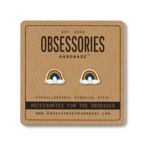 May include: A pair of rainbow stud earrings on a brown card. The earrings are white with a colorful rainbow design. The card reads "OBSESSORIES HANDMADE" and "ACCESSORIES FOR THE OBSESSED".