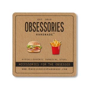 May include: A square, brown card with the text "OBSESSORIES HANDMADE" and the website address. The card features illustrations of a hamburger and a container of french fries. The text "ACCESSORIES FOR THE OBSESSED" is also present.