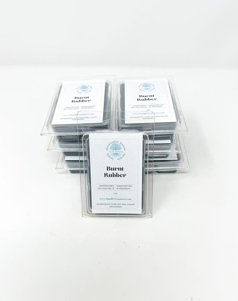 May include: Stacked clear plastic containers holding soy wax melts. Each container has a white label with the text "Burnt Rubber". The labels also include the words "Handpoured, Handcrafted Soy Wax Melts in Arkansas".