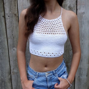 May include: White crochet halter top with a geometric pattern. The top is cropped and has a relaxed fit.