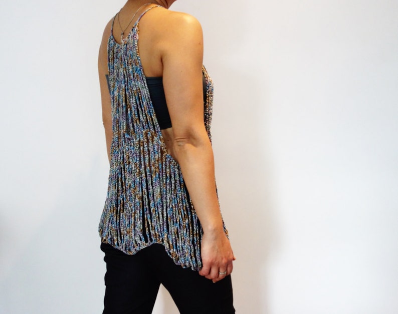 May include: A crocheted top with a multicolored, beaded design. The top has a loose, flowing fit and a scoop neck.