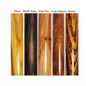May include: Close-up of five different types of wood: Olive, Black Palm, Irish Yew, Irish Walnut, and Bocote. Each wood sample is a cylinder with a smooth, polished finish.