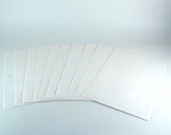 May include: A collection of white, rectangular paper sheets fanned out against a light background. The sheets are arranged in a semi-circular pattern, with each sheet slightly overlapping the next. The paper appears to be plain and untextured.