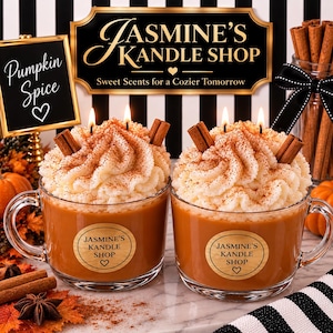 May include: Two glass mugs filled with orange wax, topped with white whipped wax and cinnamon sticks. Each mug features a round label reading Jasmine's Kandle Shop with a heart. A sign in the background reads Jasmine's Kandle Shop and Pumpkin Spice.