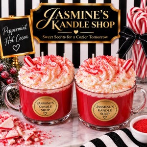 May include: Two red candles in clear glass mugs topped with white wax whipped cream, red sprinkles, and a peppermint candy stick. Each mug features a gold circular label reading Jasmine's Kandle Shop with a heart icon below the text.
