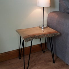 Live edge end table with black, two prong hairpin legs.