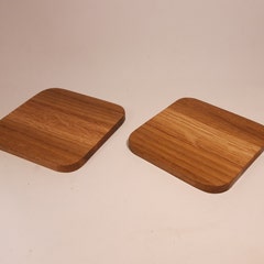 Two beautiful handmade oak coasters in a simple, elegant square design.