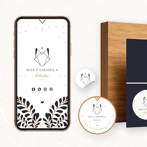 May include: A smartphone, stickers, and a print featuring the "Mãe Camomila" logo. The logo is a geometric fox head with a crescent moon. A woman in a rust-colored dress is also pictured.