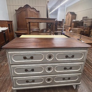 May include: A set of three ceramic mugs with a speckled, cream-colored glaze. Each mug features a different hand-painted floral design in shades of blue, green, and yellow. The mugs have a simple, rounded shape and a comfortable handle.